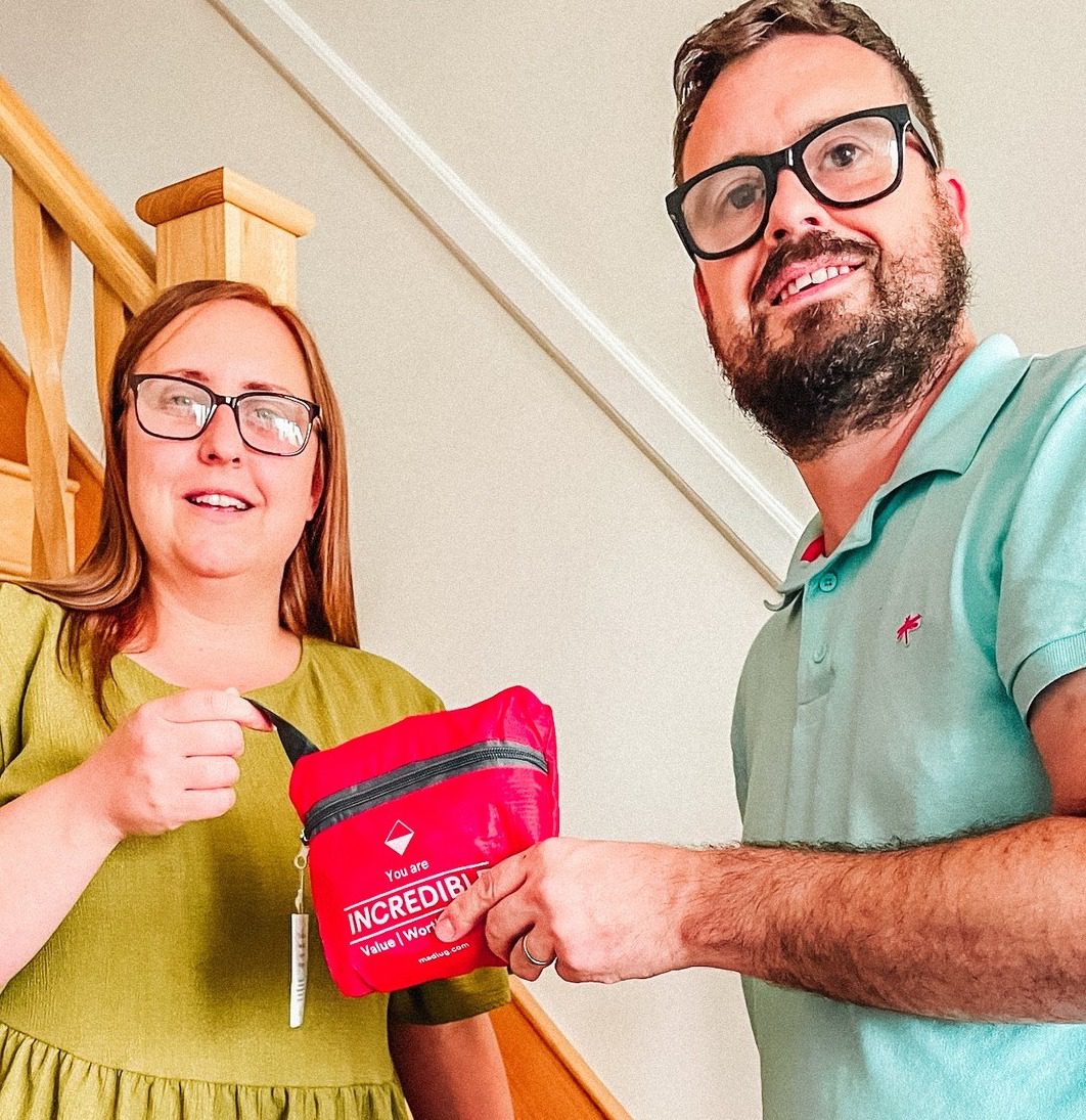 Adult and child holding a red request a bag